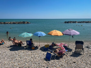 people at the beach, colourful umbrellas 