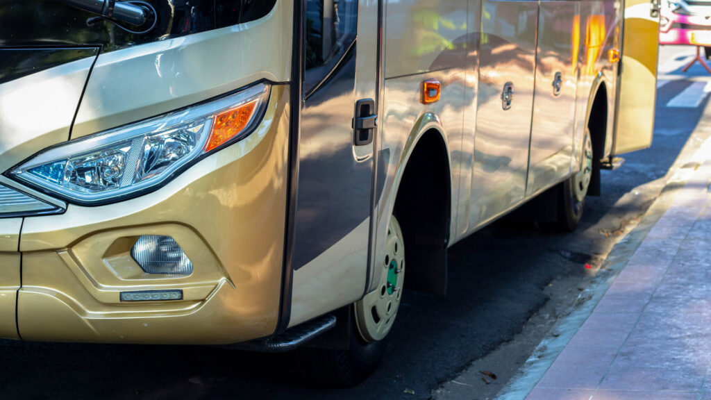 Yellow bus. Detail of headlights and tyres